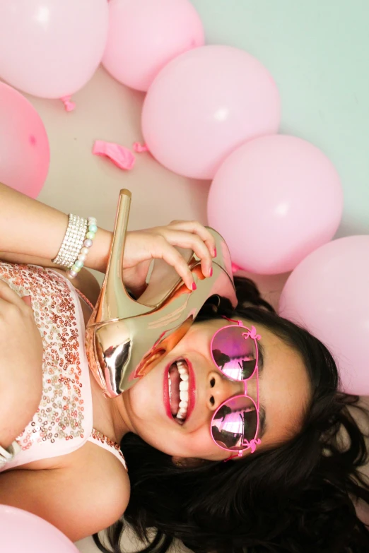 a woman wearing pink glasses and some balloons