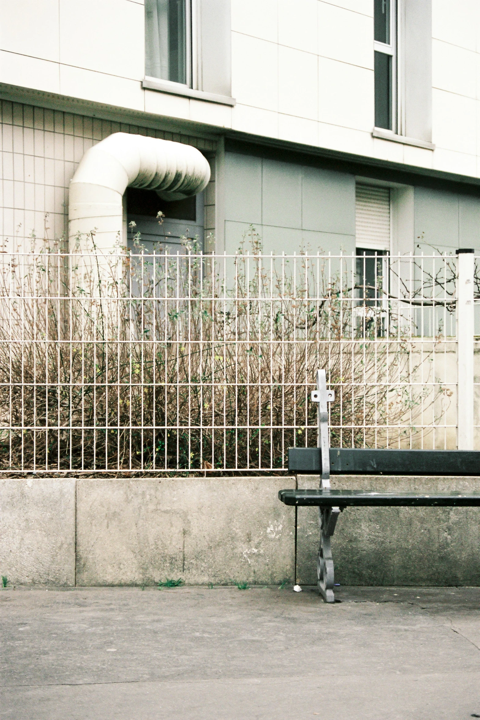 bench in front of a building and fence