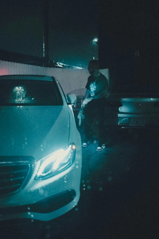 a woman sitting in front of a car parked outside