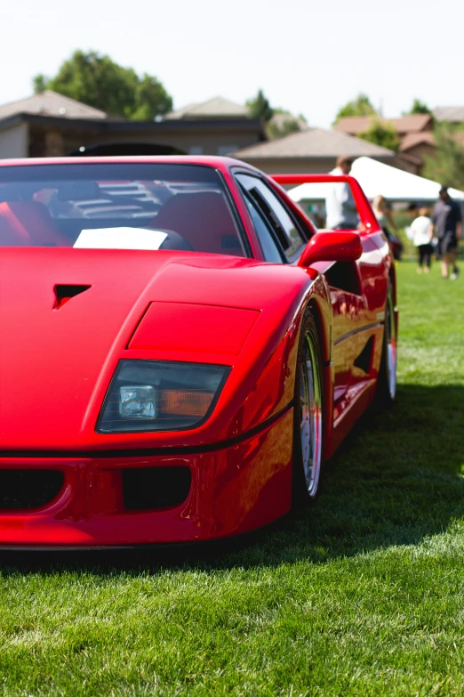 the front of a red, sporty car parked on grass