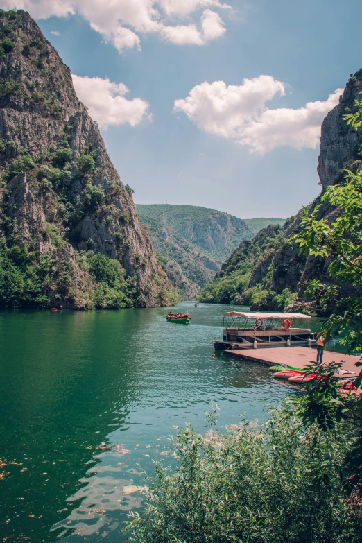 several paddle boats docked at the bottom of a deep blue river