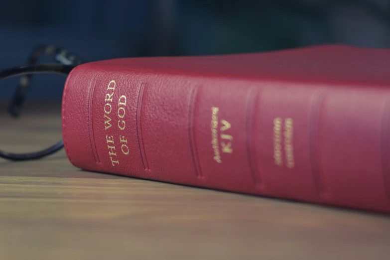 a close up of a red book with glasses on it