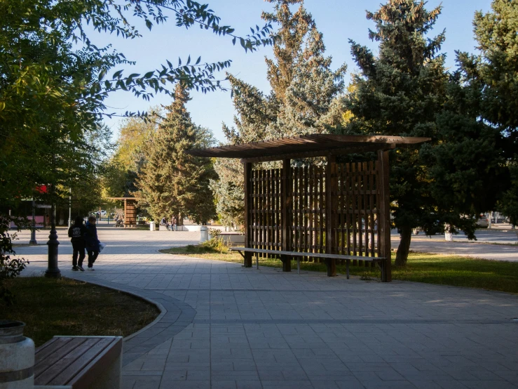 the gazebo is sitting in the park by the trees