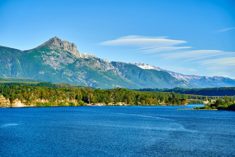 a lake with mountains in the distance and clouds in the sky