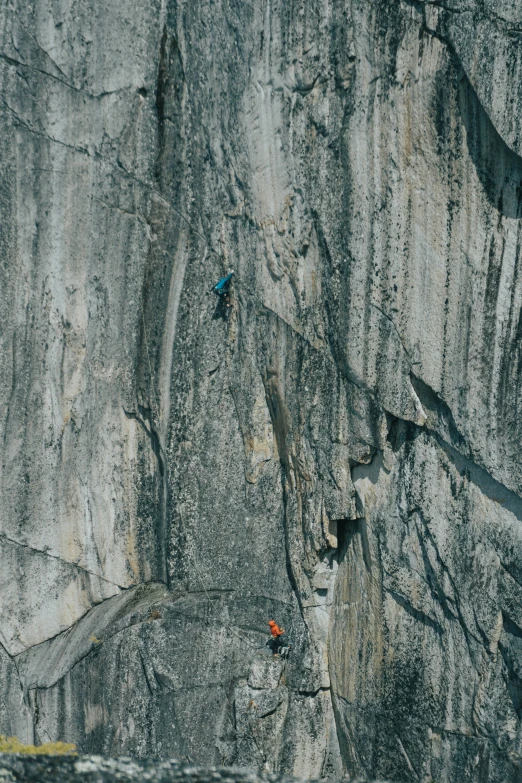 a rock climber ascending up the side of a mountain