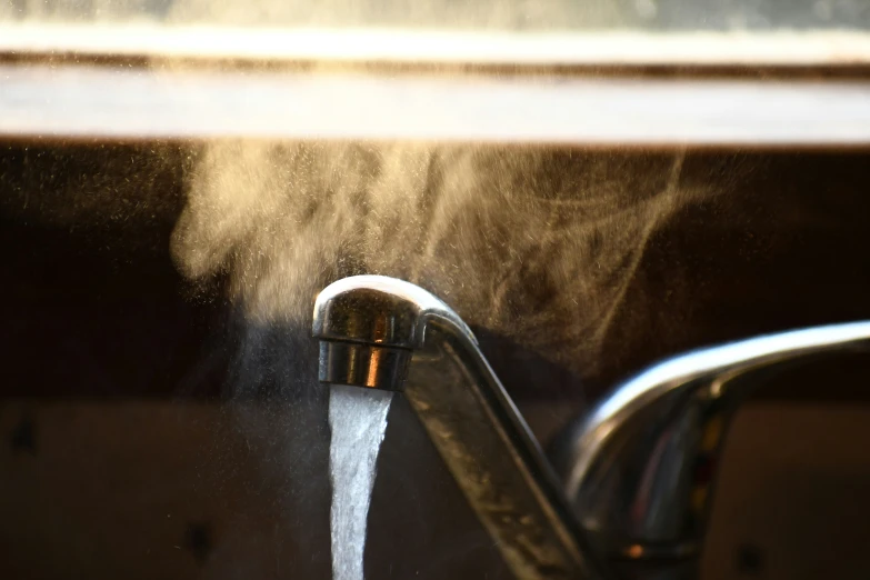 water from the faucet spewing out a window