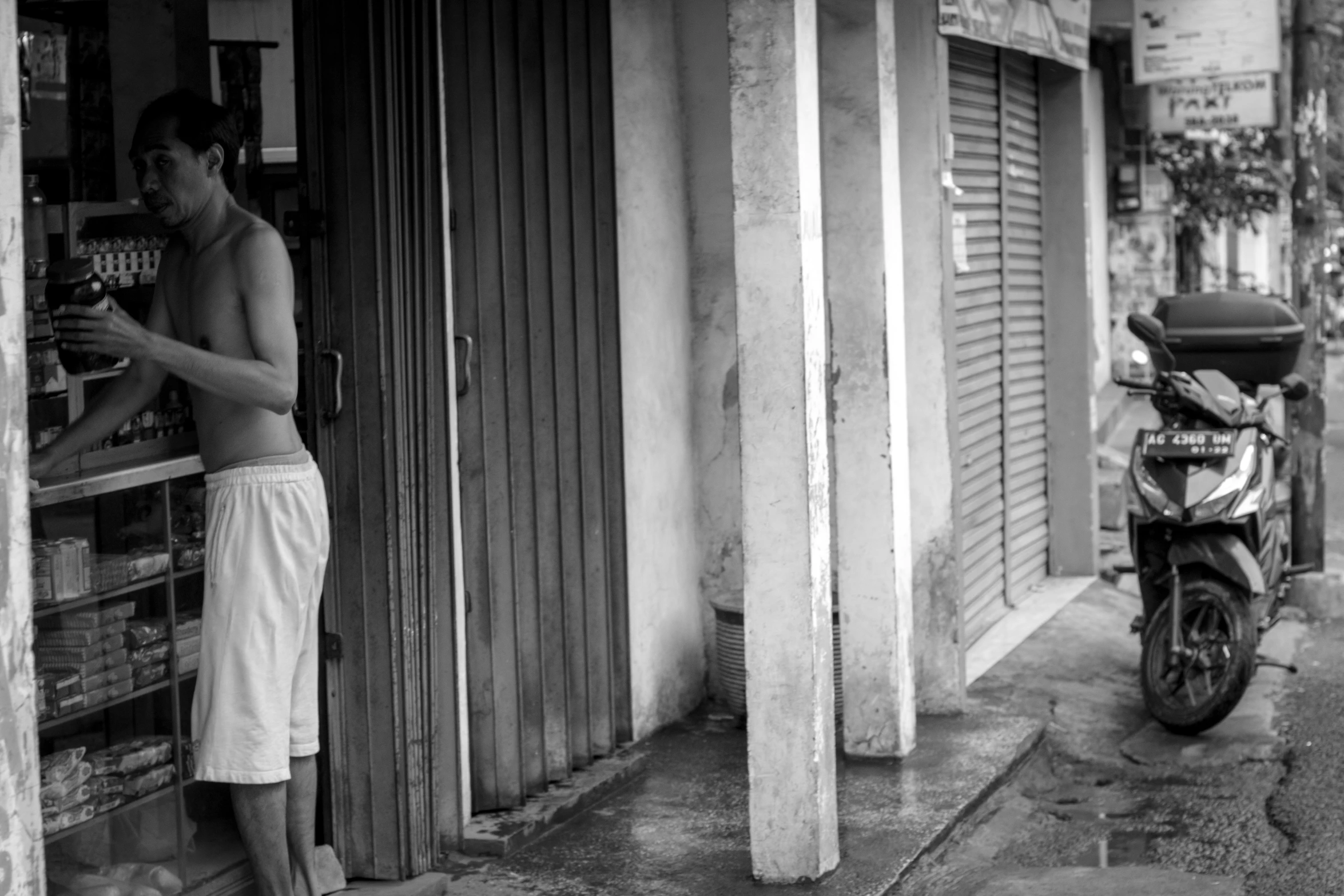 a man in shorts leaning up against a building