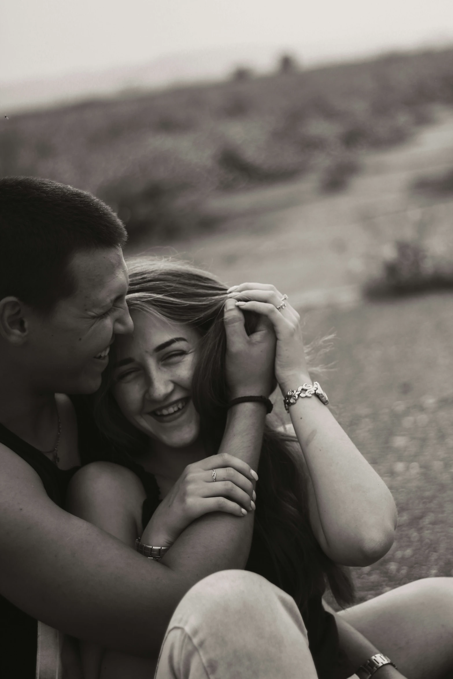 a couple sits on the road with their arms around each other