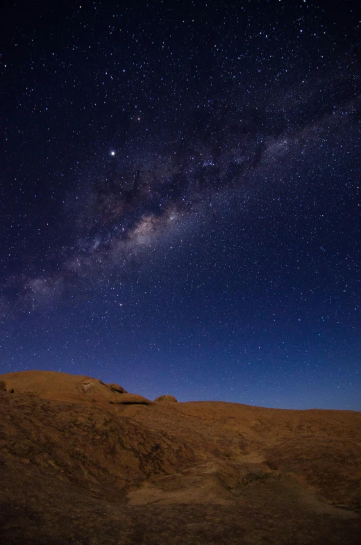 the night sky with stars above sand dunes