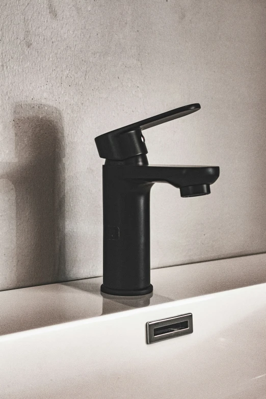 a black bathroom faucet sitting next to a white shelf
