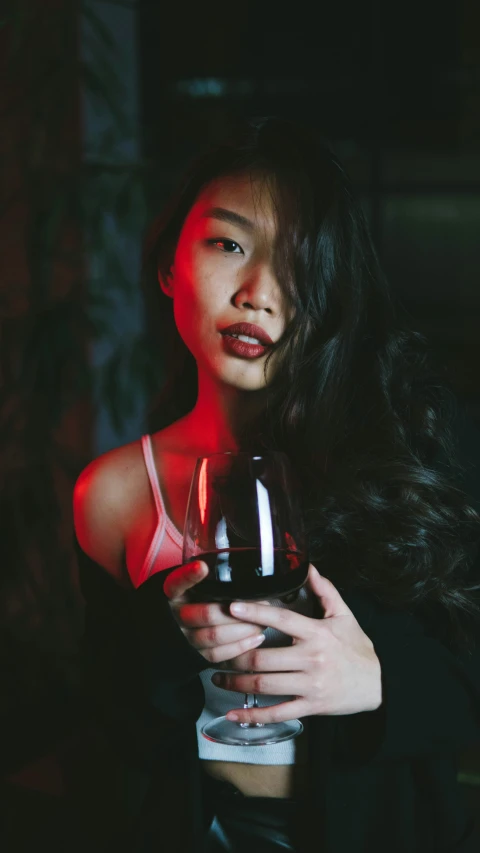 a young woman holding a glass of wine in her hands