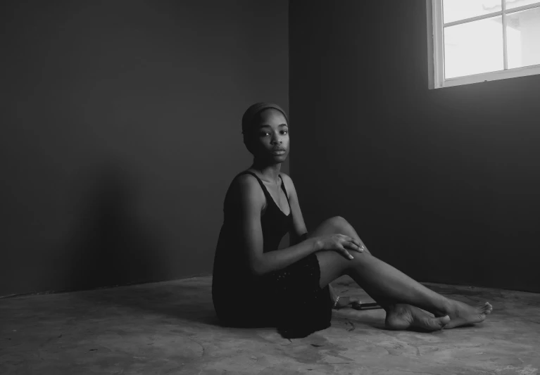 a young woman sitting on the floor of an empty room