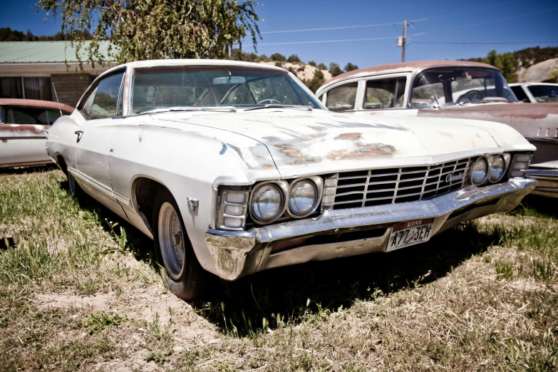 some old cars parked in a grass field