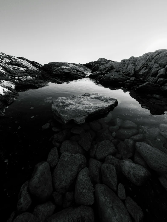 the view from the top of a mountain looking at rocks and water