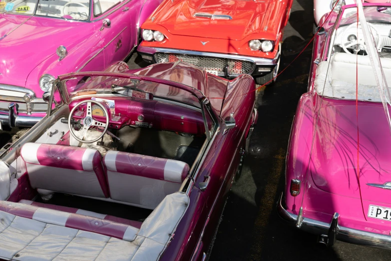 several classic cars are lined up on the pavement