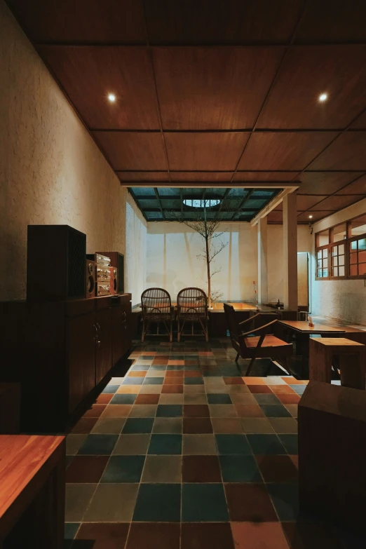 a dimly lit room with chairs, tables and desks