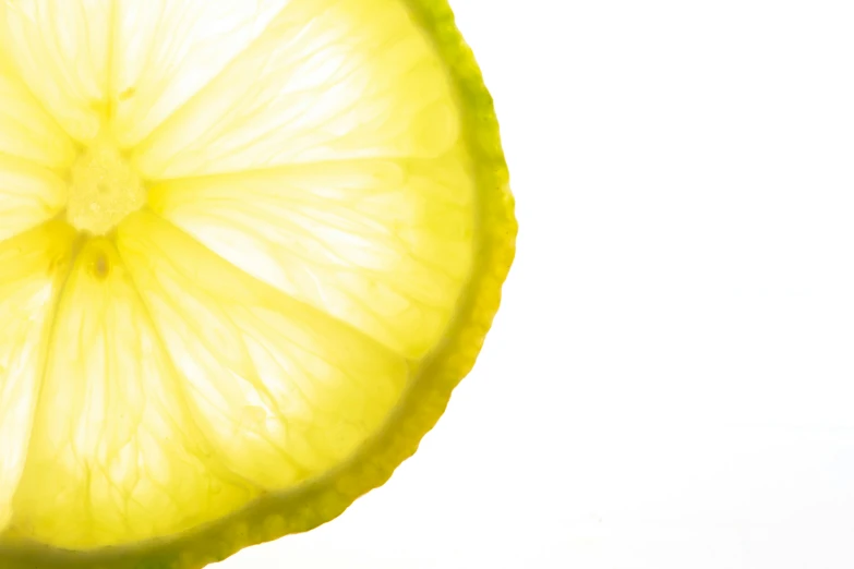 a lemon slice on a white background with a reflection in the glass