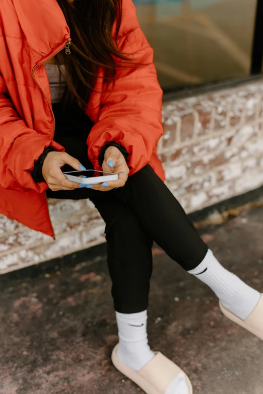 a woman sitting on the ground while using her phone