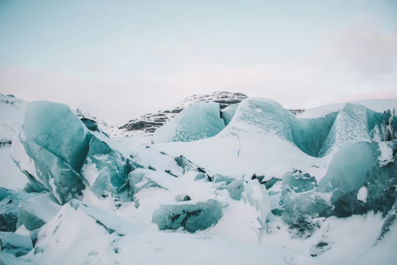 a large snow covered mountain side by a hill