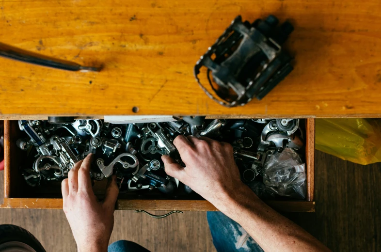 a person holding up an assortment of screws in a box