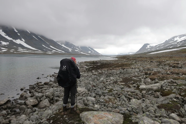 the person is looking out over the rocky shoreline