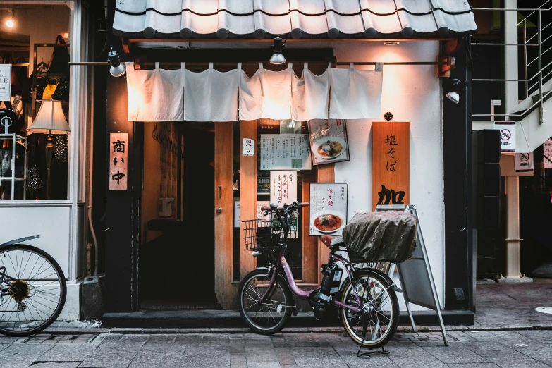 a woman and two bicycles are parked in front of a store