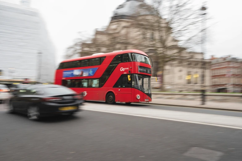 a double decker bus and a car on a city street