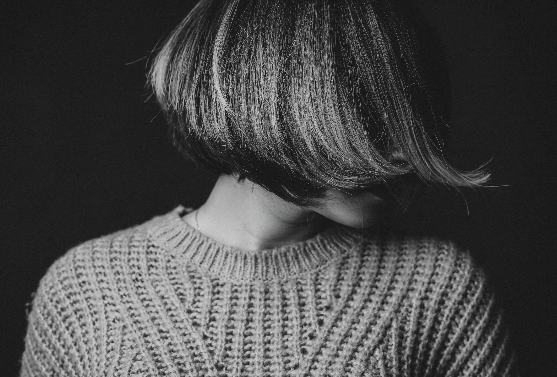 a girl standing in a sweater looking to her right