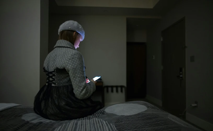 the woman in the dark is using her phone