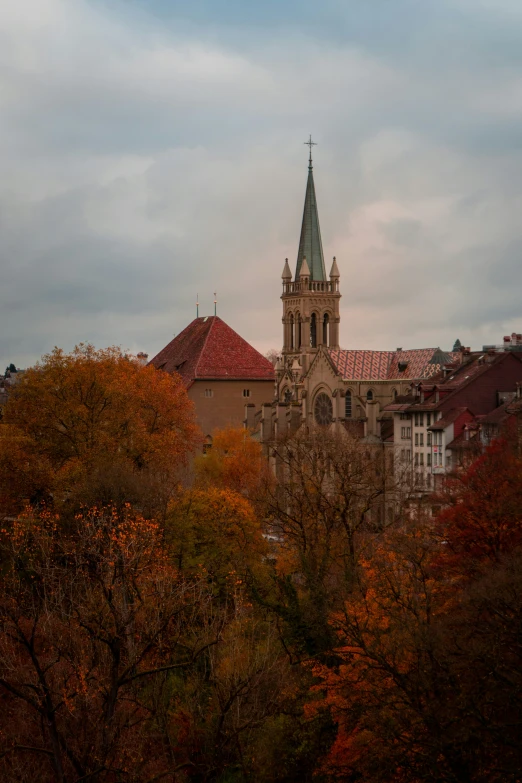 a church is sitting among the fall trees