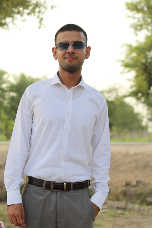 a man in sunglasses standing next to an old building