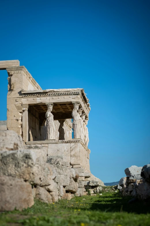 two statues sitting in the grass near some large rocks