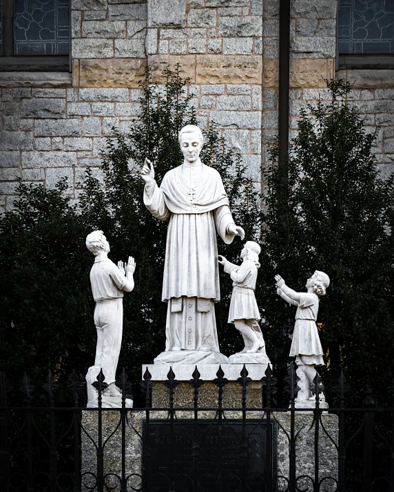 the statue of jesus with children in front of the building