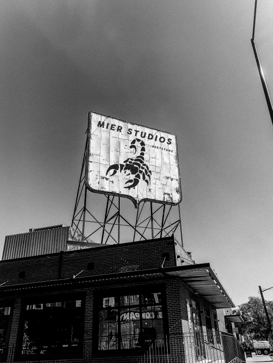 black and white pograph of a large sign on top of a building