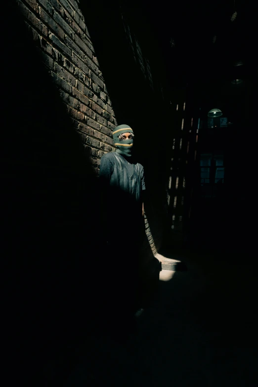 a person in the dark with their head covered by a mask