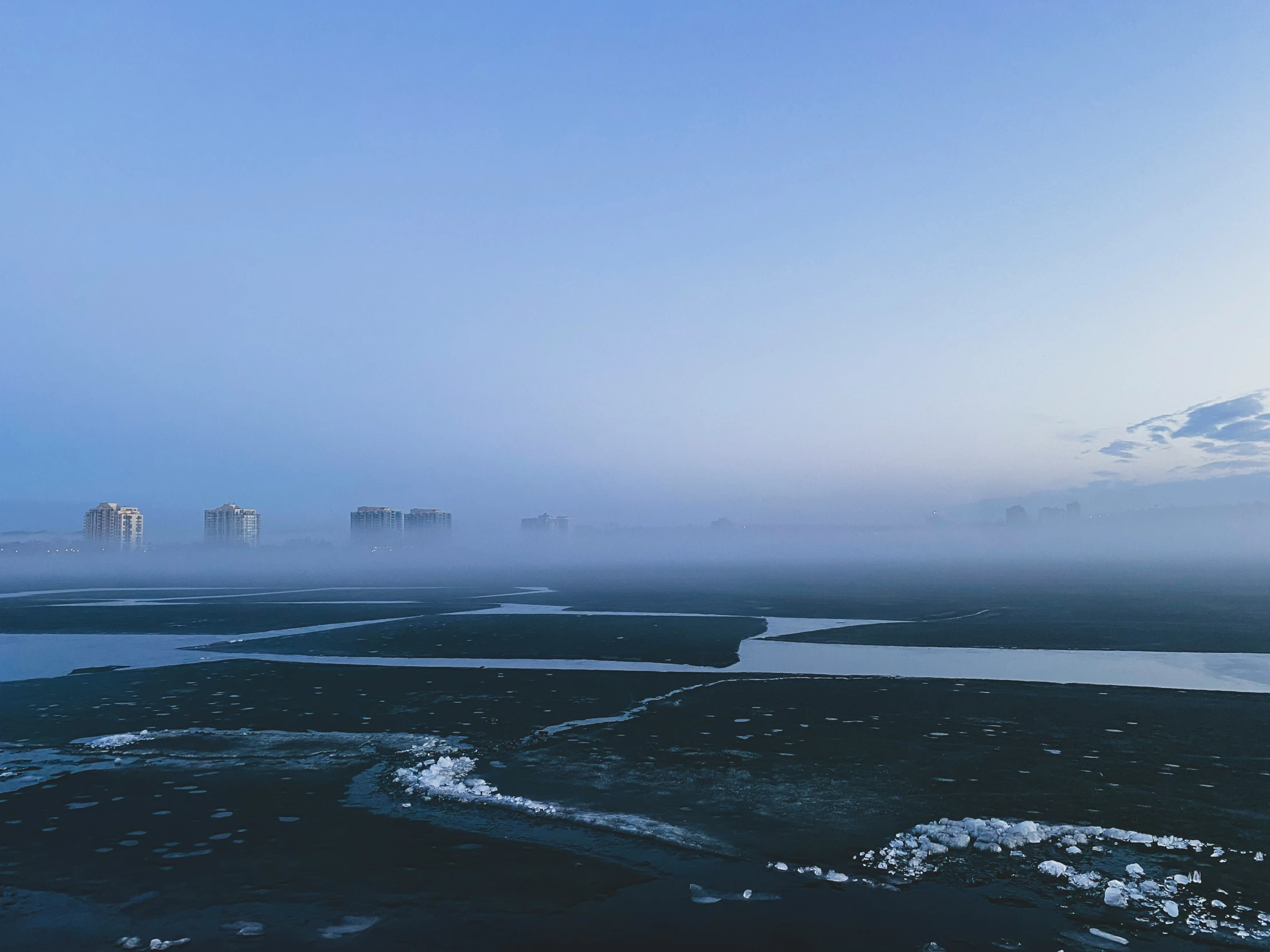 some snow water clouds and buildings and trees