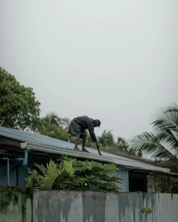 a man that is on a roof and standing on a rail