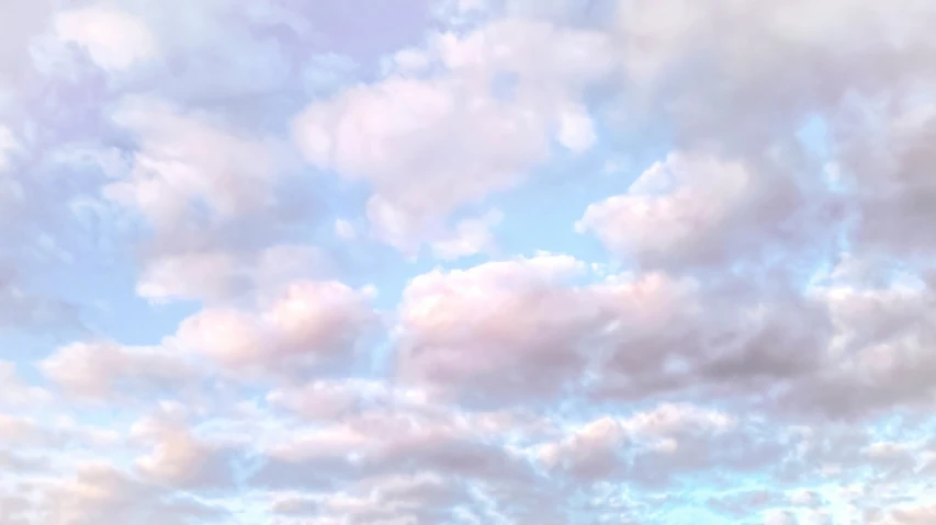 clouds in the sky and people walking on a beach