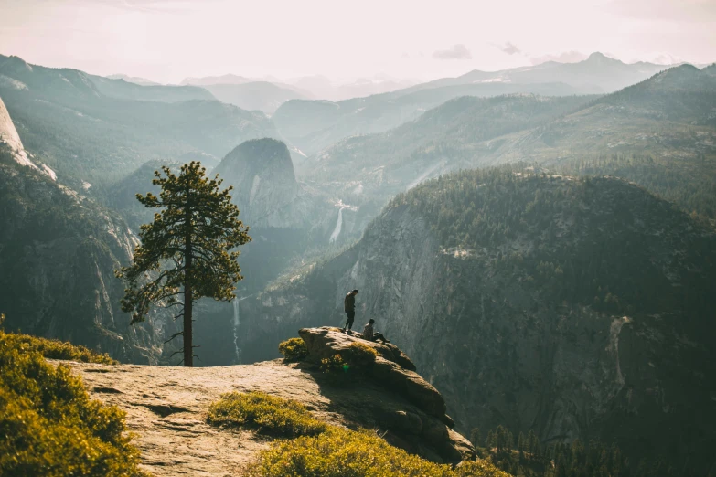 there are two men standing on the top of a mountain