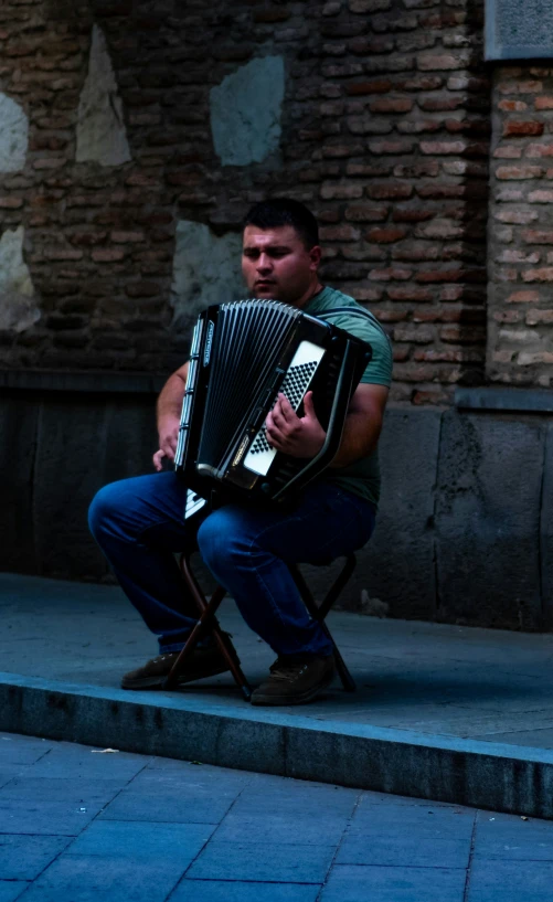 a man sitting on a step holding an accordian