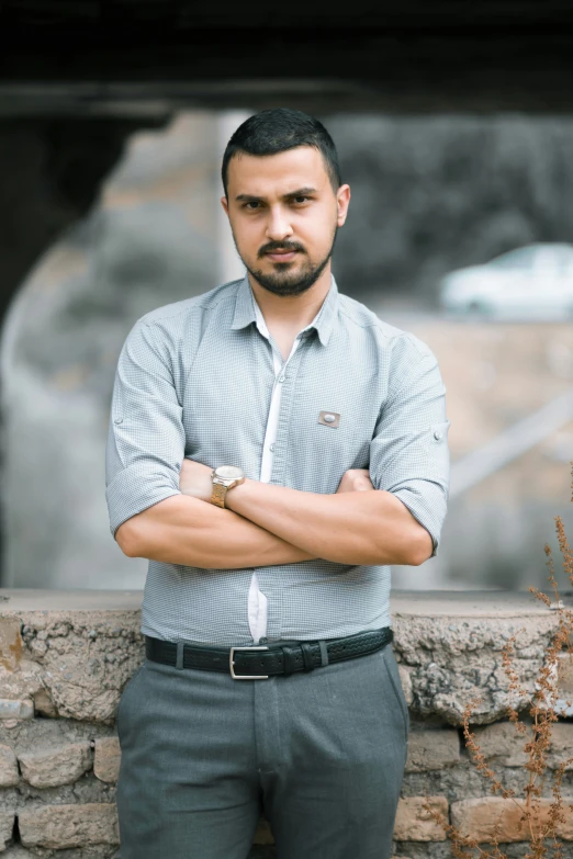 a man in business attire with his arms crossed