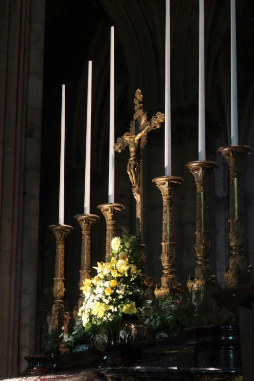 a cross is seen next to a bunch of flowers