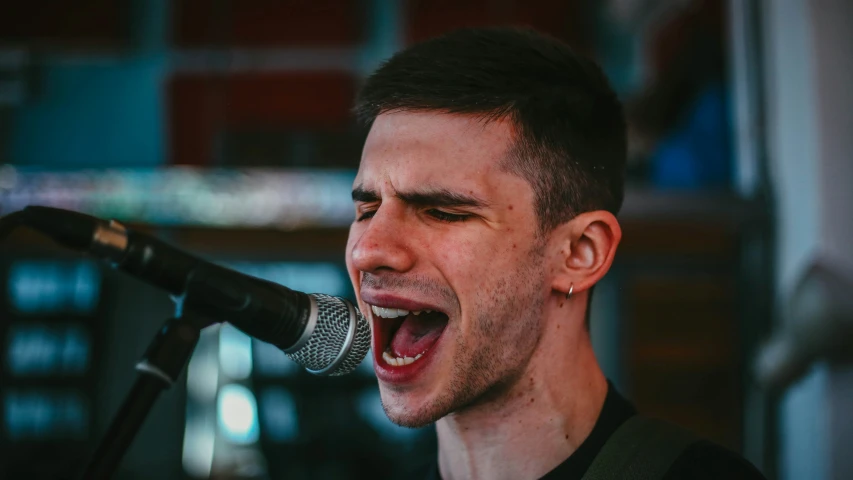 a man standing in front of a microphone while singing