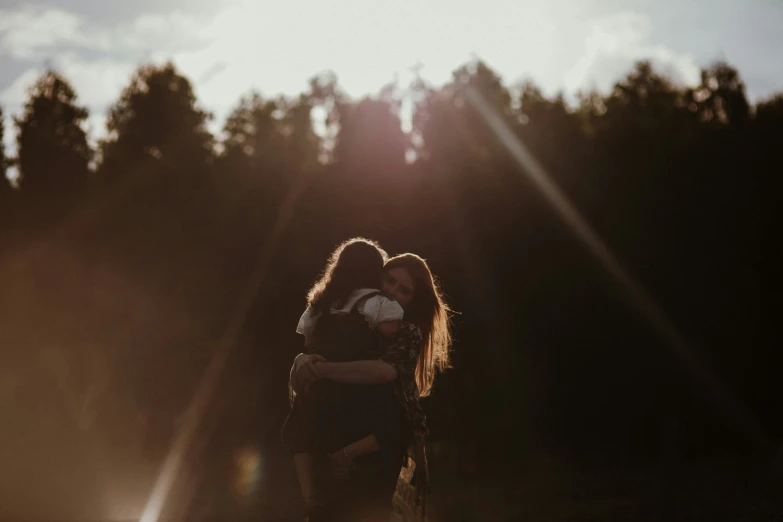 a man and woman emcing in a field in front of trees