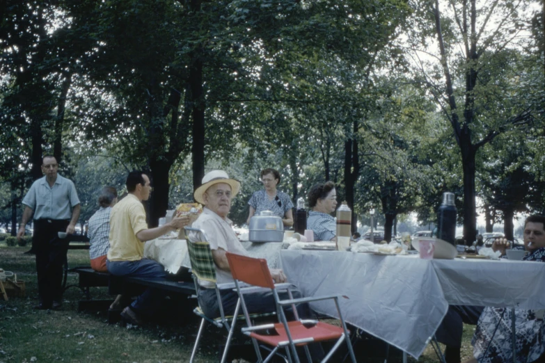 people sitting at an outside dining table with food