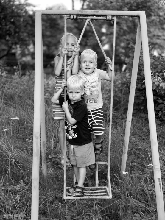 two children on a swing in the grass