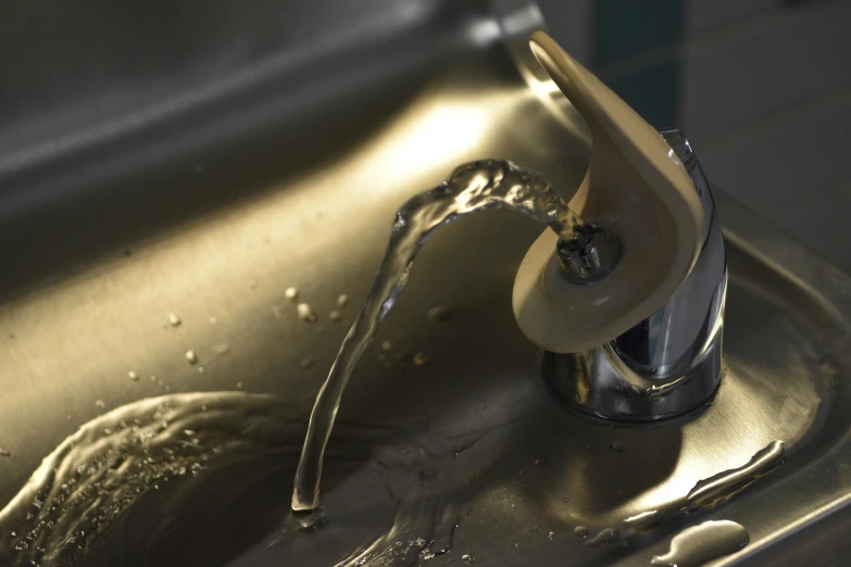 a close up image of the water running from a sink