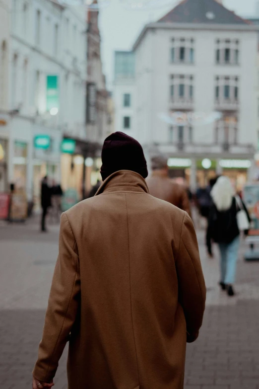 a man walks down a busy street in winter