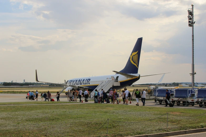 people gather to see a large plane that is parked on the runway