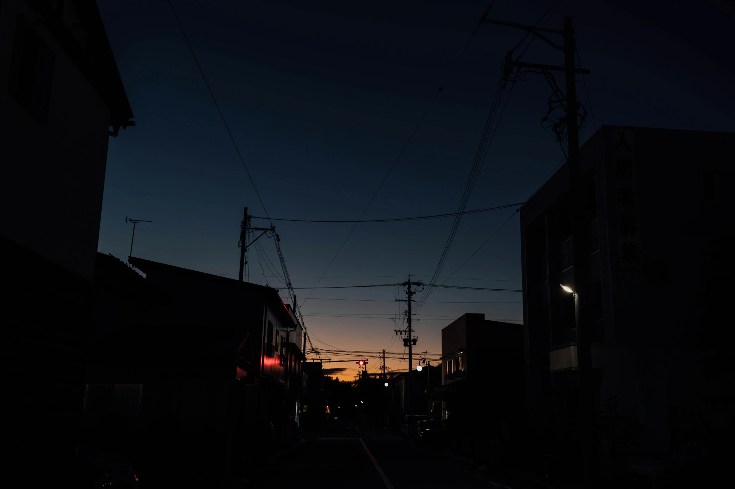 a city street at night with power lines above it